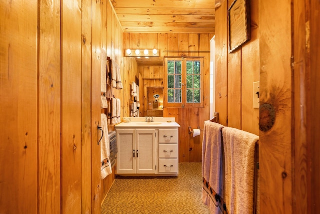 bathroom with wooden walls, vanity, and wooden ceiling