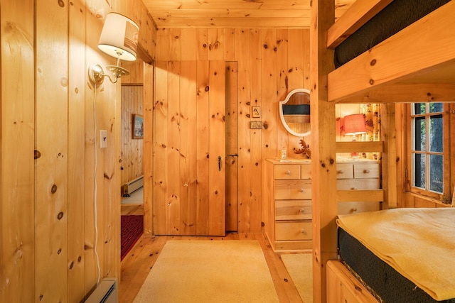 bathroom featuring wood walls, wood finished floors, and a baseboard heating unit