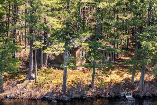 view of home's exterior featuring log veneer siding and a water view