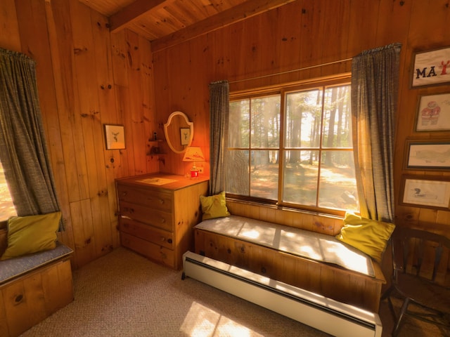 sitting room featuring a baseboard heating unit, wood walls, beam ceiling, wood ceiling, and carpet flooring
