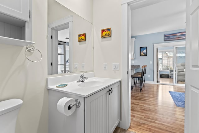 bathroom with toilet, wood finished floors, and vanity