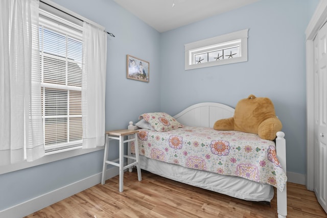 bedroom with baseboards and wood finished floors