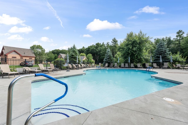 community pool with fence and a patio