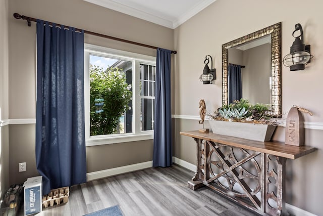 doorway to outside with crown molding, baseboards, and wood finished floors