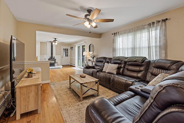 28 Poland Spring Rd, Auburn, ME 04210 - living area featuring ceiling fan, light wood finished floors, a wood stove, and a baseboard heating unit