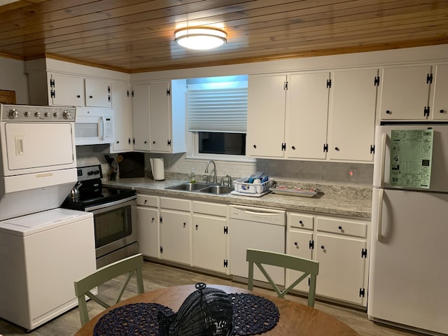 kitchen with light countertops, wooden ceiling, a sink, stacked washer / dryer, and white appliances