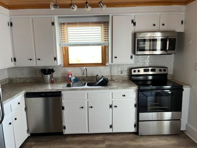 kitchen featuring light countertops, a sink, white cabinetry, tasteful backsplash, and appliances with stainless steel finishes