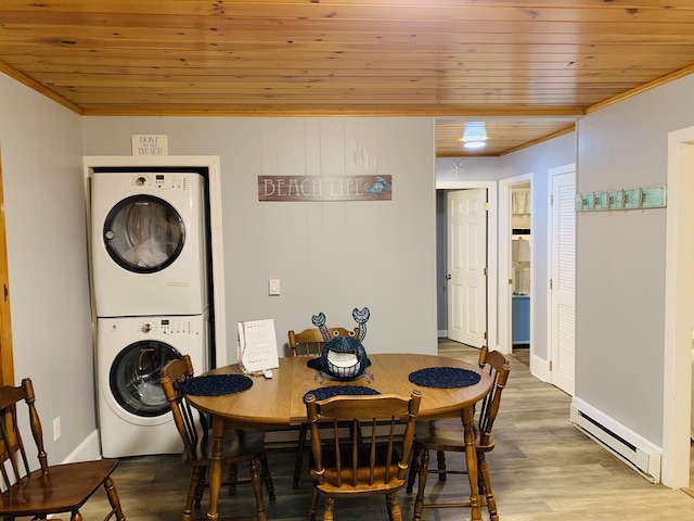dining area with stacked washer and clothes dryer, wooden ceiling, wood finished floors, and baseboard heating
