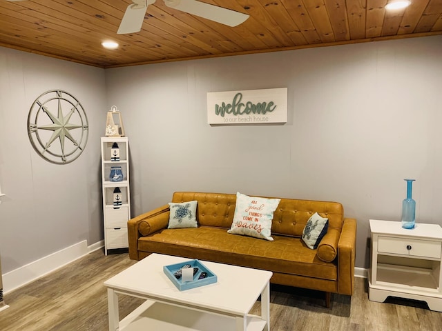 living area featuring baseboards, ceiling fan, wood finished floors, and wooden ceiling