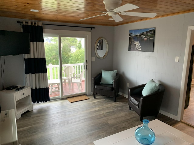 living area featuring baseboards, wood finished floors, ceiling fan, and wood ceiling