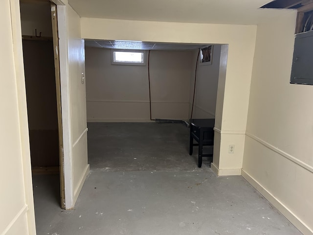 hall featuring unfinished concrete flooring and electric panel