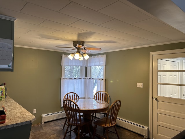 dining room with a baseboard radiator, ornamental molding, a ceiling fan, and stone finish flooring