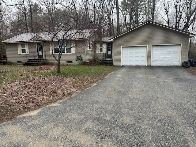 ranch-style home with an attached garage and aphalt driveway