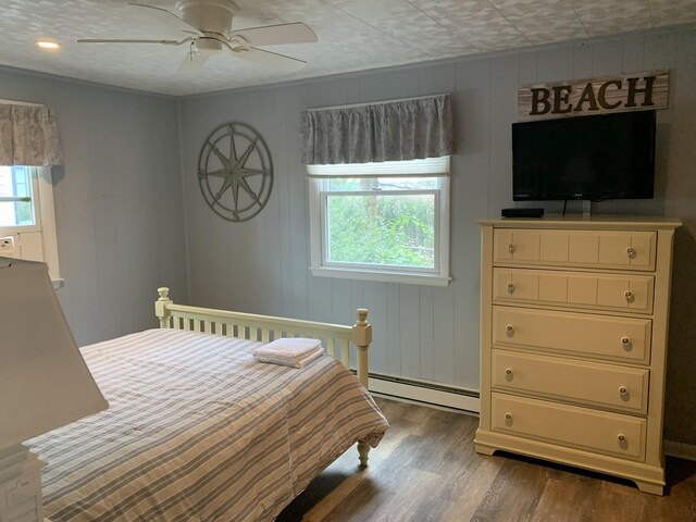 542 Ocean Ave, Wells, ME 04090 - bedroom with multiple windows, wood finished floors, a baseboard heating unit, and a ceiling fan