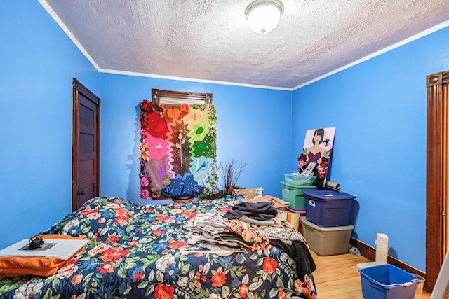 bedroom with wood finished floors, ornamental molding, and a textured ceiling