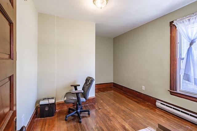 home office featuring baseboard heating, hardwood / wood-style flooring, and baseboards