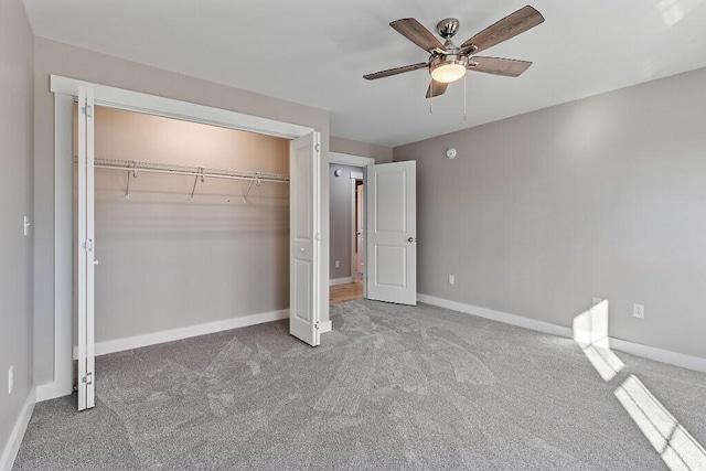 unfurnished bedroom featuring carpet floors, baseboards, a closet, and ceiling fan