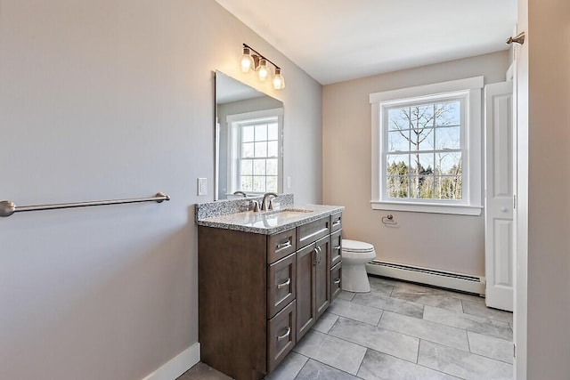 bathroom featuring toilet, vanity, baseboards, and baseboard heating