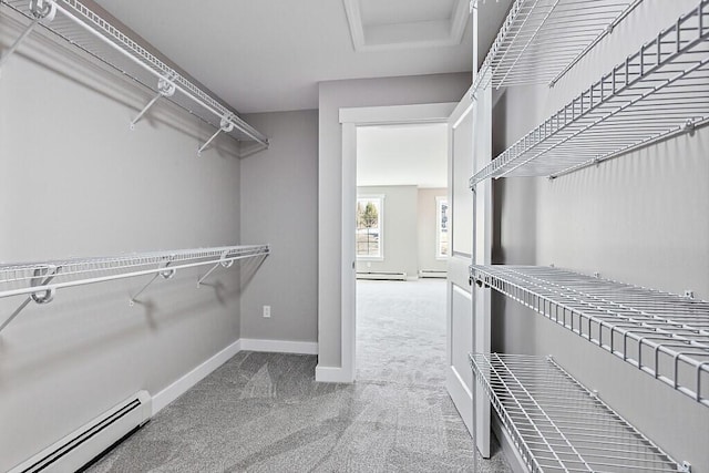 spacious closet with carpet floors, attic access, and a baseboard radiator