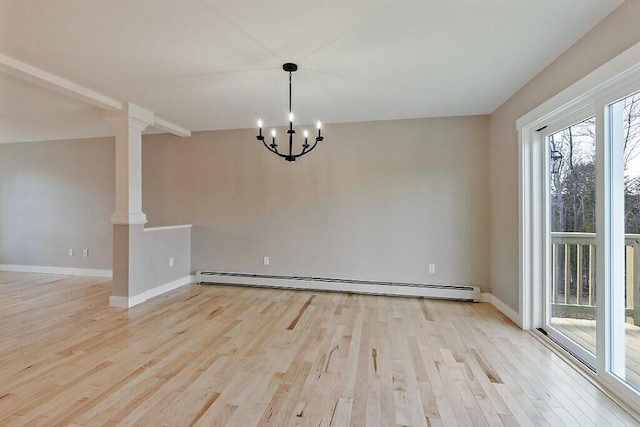 empty room featuring ornate columns, baseboards, a baseboard heating unit, light wood-style floors, and a notable chandelier