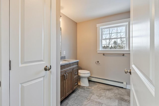 bathroom featuring a baseboard radiator, toilet, and vanity