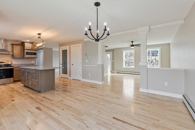 kitchen with decorative columns, open floor plan, baseboard heating, stainless steel appliances, and light wood-style floors