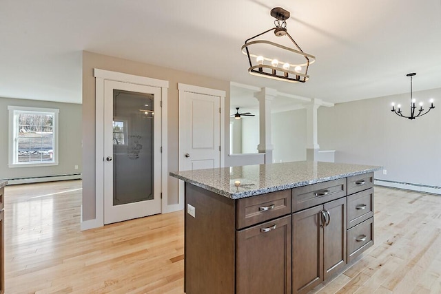 kitchen featuring hanging light fixtures, light wood finished floors, baseboard heating, and a baseboard radiator