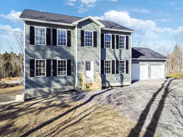 colonial inspired home with driveway and an attached garage