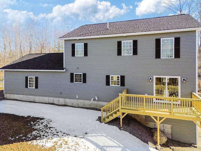 back of property with roof with shingles and a deck