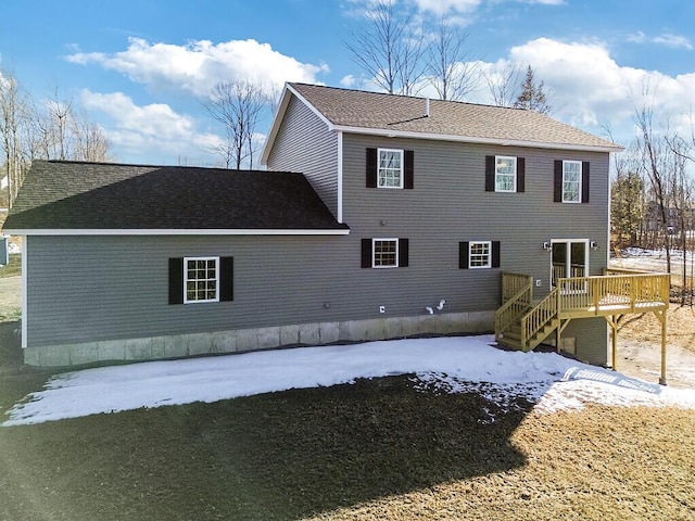 rear view of house featuring a shingled roof and a wooden deck