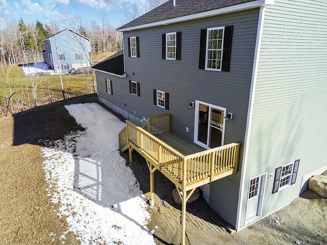 back of property featuring roof with shingles and a deck