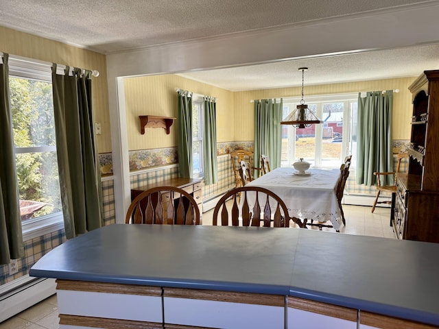 dining area featuring a baseboard heating unit, a wainscoted wall, a wealth of natural light, and a textured ceiling