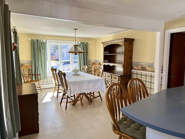 dining area featuring wallpapered walls, a textured ceiling, a baseboard radiator, and crown molding