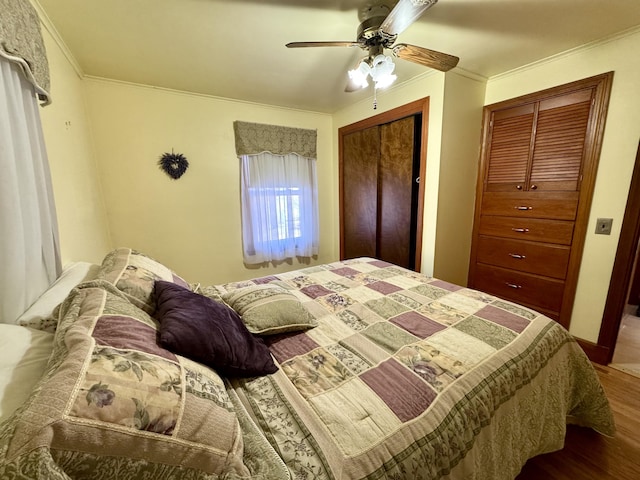 bedroom with wood finished floors, crown molding, and ceiling fan