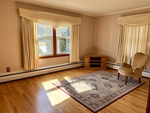 living area with a baseboard heating unit, light wood-style flooring, and crown molding
