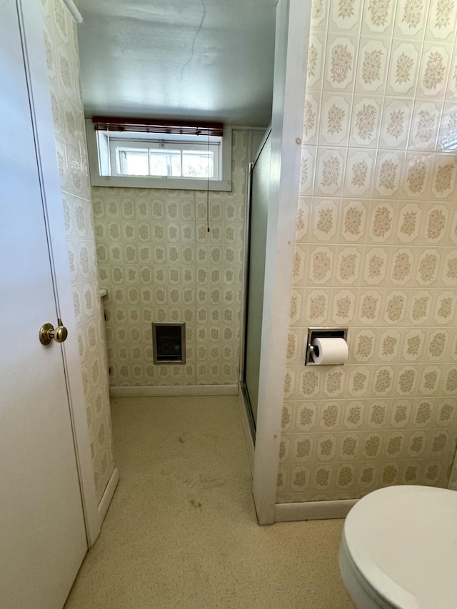 bathroom with toilet and a stall shower