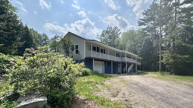 81 Maple Ridge Rd, Harrison, ME 04040 - view of front of house with dirt driveway, a garage, and a wooden deck