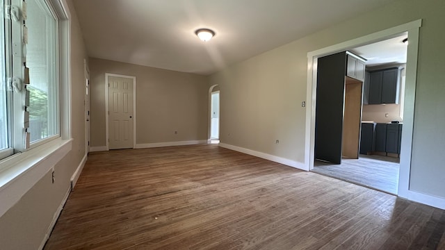 81 Maple Ridge Rd, Harrison, ME 04040 - empty room featuring arched walkways, wood finished floors, and baseboards