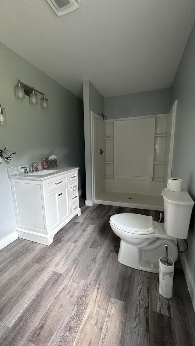 81 Maple Ridge Rd, Harrison, ME 04040 - full bathroom with toilet, a sink, wood finished floors, a shower, and baseboards