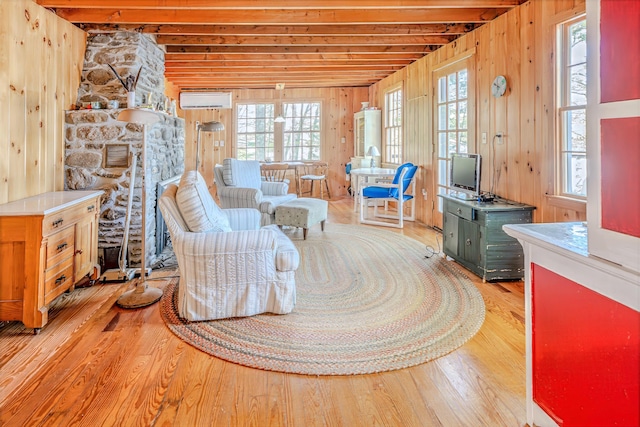 122 Oak Point Ln, Union, ME 04862 - living area with wood finished floors, healthy amount of natural light, wood walls, and a wall mounted air conditioner
