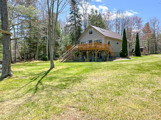 back of house with a deck, an outbuilding, stairs, and a storage unit