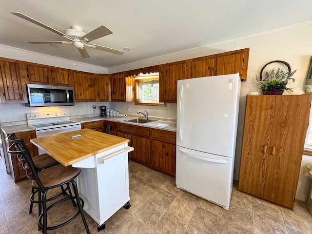 kitchen with ceiling fan, white appliances, tasteful backsplash, ornamental molding, and butcher block counters