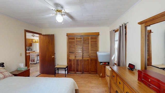bedroom featuring a closet, a ceiling fan, and light wood-style floors