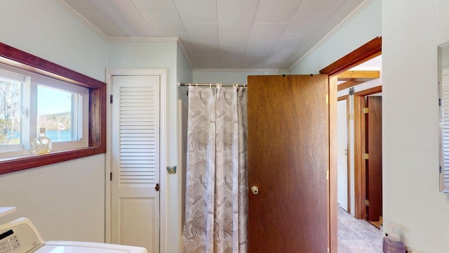 bathroom featuring crown molding, washer / dryer, and a shower with shower curtain