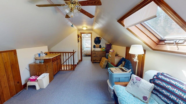 bonus room with carpet floors, ceiling fan, and vaulted ceiling with skylight