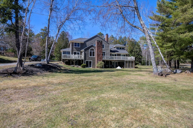 exterior space with a lawn, a deck, and a chimney