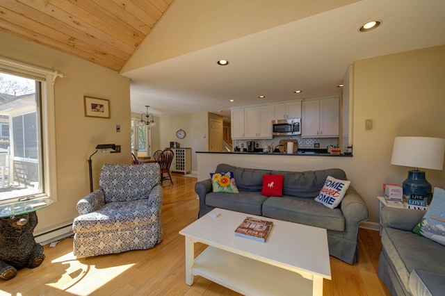 living area featuring recessed lighting, light wood-style floors, a notable chandelier, baseboard heating, and lofted ceiling