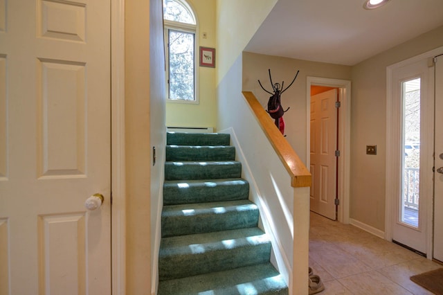 tiled entryway with stairway and baseboards