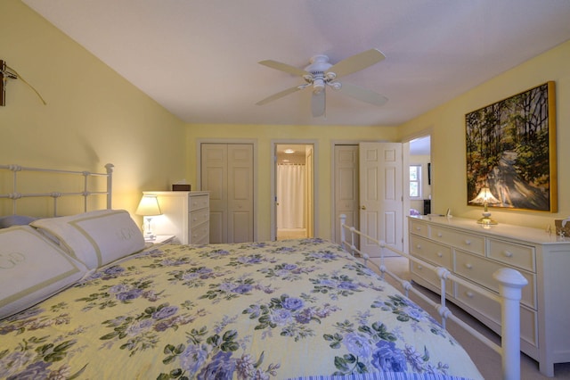 bedroom with carpet, multiple closets, and a ceiling fan