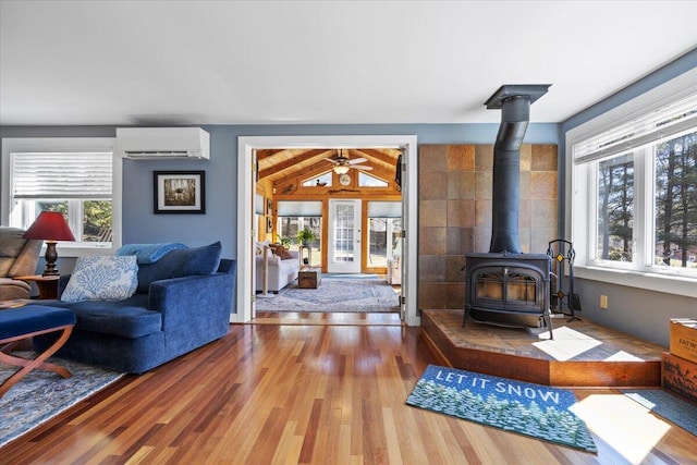 374 Youngs Ridge Rd, Acton, ME 04001 - living area with a wall unit AC, wood finished floors, a wood stove, and ceiling fan